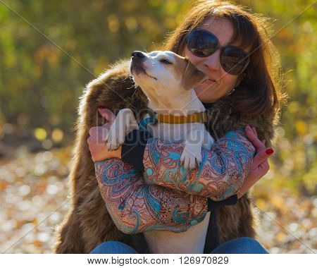 portrait of a woman with a dog on holiday in the autumn park  age of 40 years