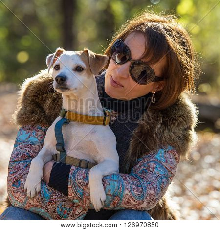 portrait of a woman with a dog on holiday in the autumn park  age of 40 years
