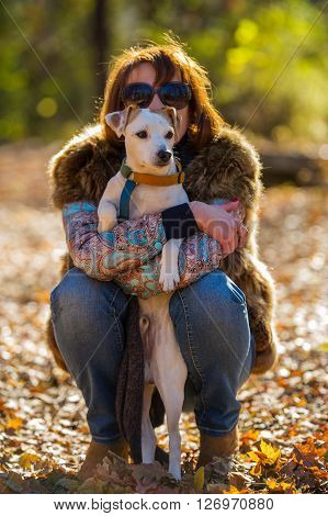 portrait of a woman with a dog on holiday in the autumn park  age of 40 years
