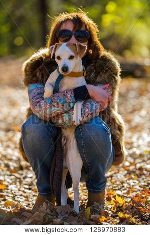 portrait of a woman with a dog on holiday in the autumn park  age of 40 years