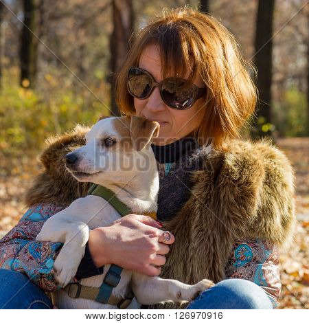 portrait of a woman with a dog on holiday in the autumn park  age of 40 years