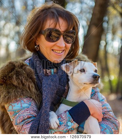portrait of a woman with a dog on holiday in the autumn park  age of 40 years