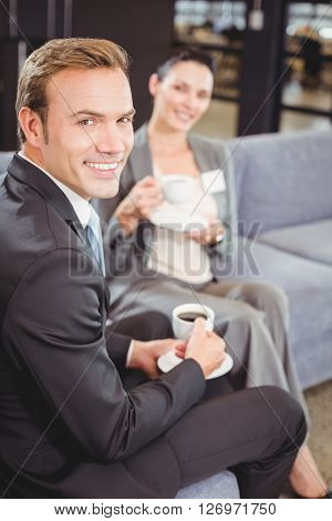 Portrait of businessman and businesswoman having tea during breaktime in office
