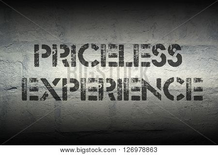 priceless experience stencil print on the grunge white brick wall