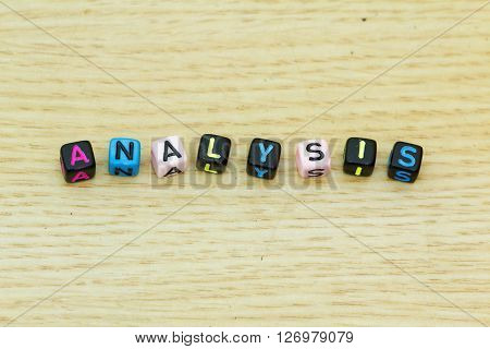 Word ANALYSIS arranged from plastic alphabet block. Concept of economy, financial, study, research.