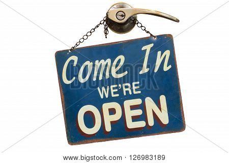 old rusty metal plate with word Come In We're Open haning on a knob and door handle isolated on white background