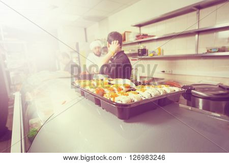 male cooks preparing sushi in the restaurant kitchen.