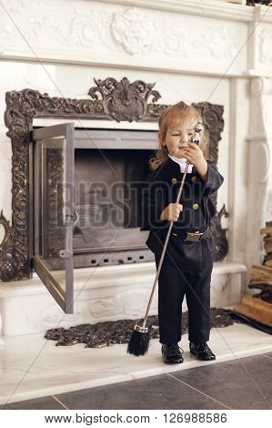 Girl as a chimney sweep against fireplace. Lucky New Year's Eve and New Year.
