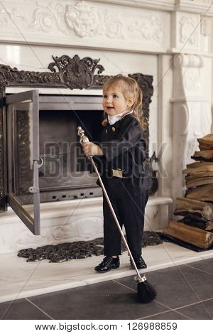 Girl as a chimney sweep against fireplace. Lucky New Year's Eve and New Year.