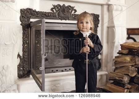 Girl as a chimney sweep against fireplace. Lucky New Year's Eve and New Year.