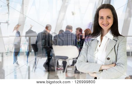 Attractive young woman in office against of glass reflection and business meeting going at the background