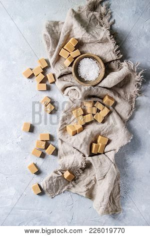 Salted Caramel Fudge Candy Served With Fleur De Sel In Wooden Bowl Over Grey Texture Background With
