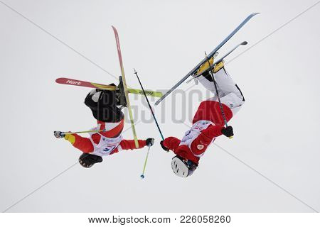 KRASNOE OZERO, LENINGRAD REGION, RUSSIA - FEBRUARY 1, 2018: Dmitry Kolesnikov (2) and Andrey Uglovski, both of Russia, compete in dual mogul during Freestyle Europa Cup competitions