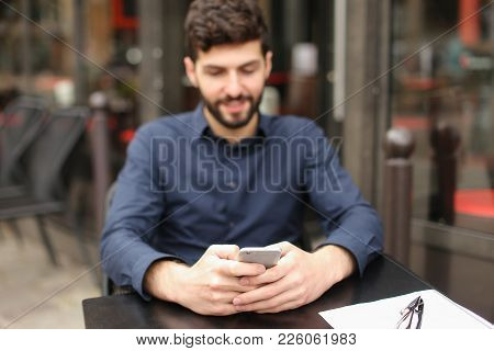Gladden Male Person Sitting At Cafe Table And Chatting With Wife By Smartphone With Close Up Face In