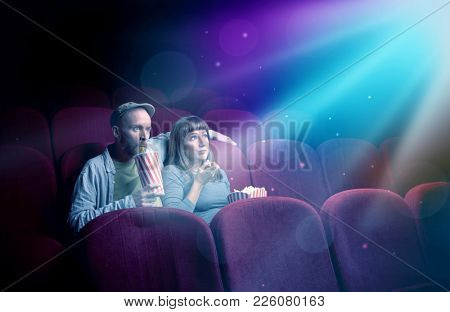 Teenager couple cuddling and watching the climax part of the movie