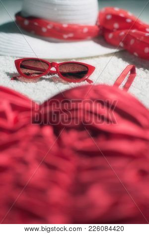 Vintage Summer Hat, Red Sunglasses And Swimsuit Displayed On White Carpet Floor.