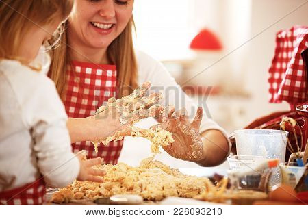 Mother And Daughter Measuring Ingredients To Make Dough
