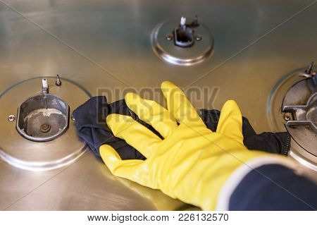 A Woman In Protective Gloves Washes The Gas Stove