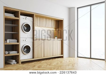 White Laundry Room Interior With Wooden Countertops, A Closet And Built In Washing Machines. Side Vi