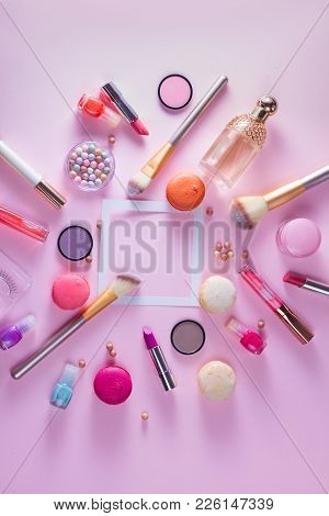 Make Up Products And Macaroons Flat Lay Frame With Copy Space On Pink Background, Top View Scene