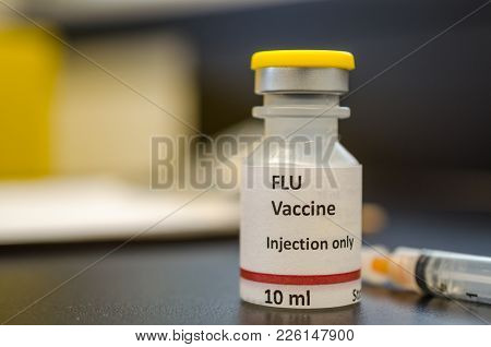 A Flu Vaccine Vial With Injection Syringe