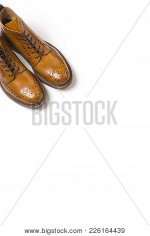 Footwear Ideas. Pair Of Separate Luxury Tan Brogue Boots On Pure White Background With Copy Space.ve