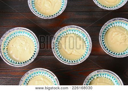 Dough In Molds For Muffins On A Wooden Table