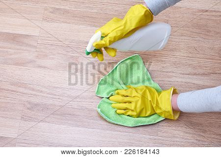A Picture Of Hands In Yellow Gloves Cleaning The Floor.