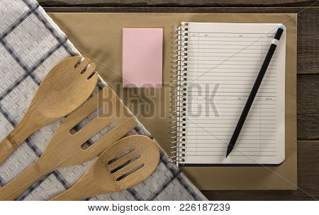 Wooden Kitchen Appliances Napkin And Notebook, On A Wood Background.
