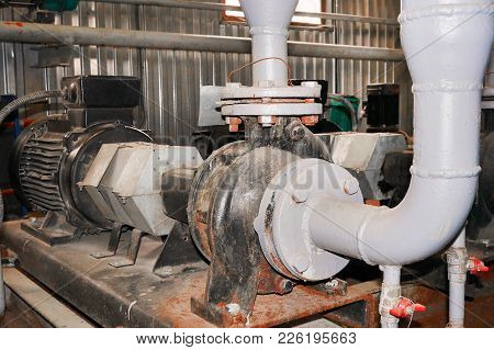 Old Motor Connected With A Pump For Water Supply Conduit.