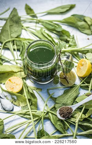 Juice Of Spinach,spinacia Oleracea Or Paalak With Sliced Lemons,citrus × Limon On  A Silver Wooden S