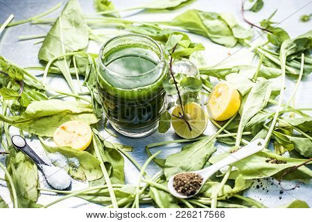Juice Of Spinach,spinacia Oleracea Or Paalak With Sliced Lemons,citrus × Limon On  A Silver Wooden S