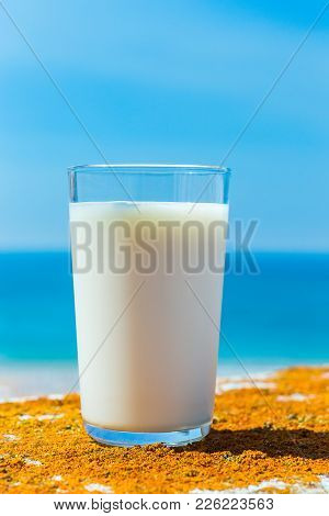 Glass Filled With Cow Milk Blue Sea And Sky