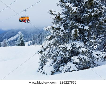 Chair Lift With Skiers At Alps Ski Resort