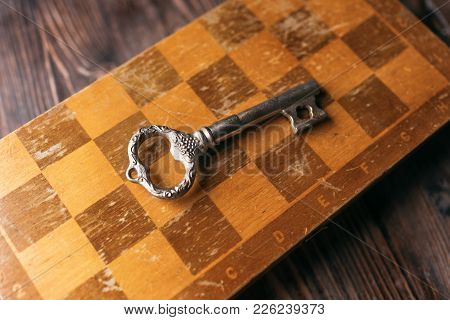 Vintage Key On An Old Chessboard, View From Above