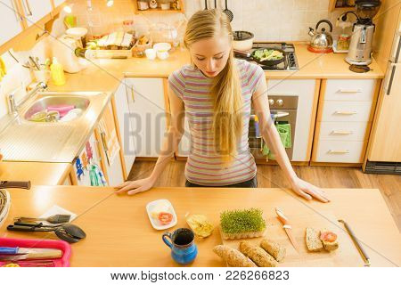 Happy Woman In Kitchen Holding Knife Making Healthy Sandwich With Salami And Cuckooflower. Diet Brea