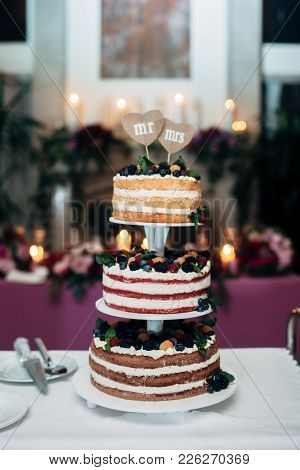 Three-tiered Wedding Cake With Blueberries, Raspberries And Berries, Two Heart Form Plates On The To