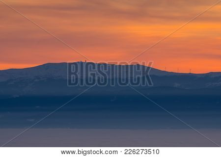 View From Mountain Schoeckl Over Low Stratus To Mountain Koralpe With Pinwheels And Sunset