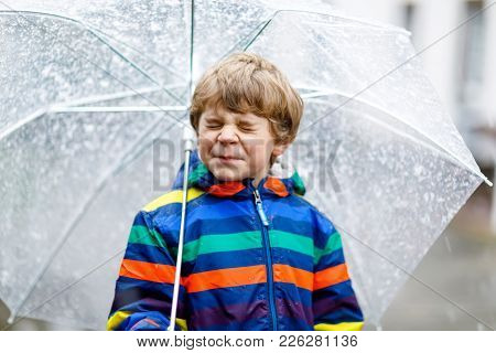 Beautiful Little Kid Boy On Way To School Walking During Sleet, Rain And Snow With An Umbrella On Co