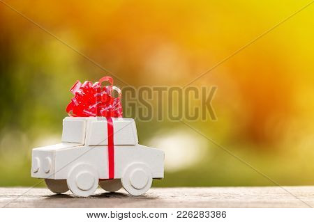 Car Model Tied With Red Ribbon Put On The Wood In Public Park , Loan And Saving For Buy A New Car As