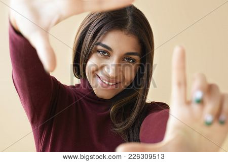 Studio Shot Of Grumpy Frowning Mixed Race Girl With Straight Dark Hair Staring At Camera With Suspic
