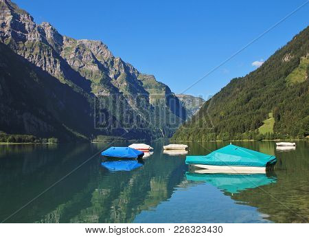 Summer Day At Lake Klontalersee, Switzerland. Fishing Boats. Glaernisch, Mountain Range.