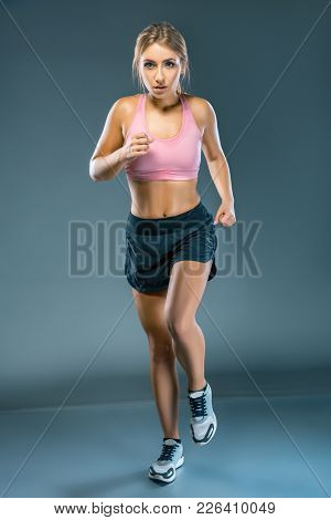 Stopped Motion Front View Of Focused Female Athlete Running To The Camera. Full Body Length Portrait