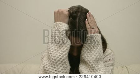Sad young woman on the couch at home, she is depressed and lonely.