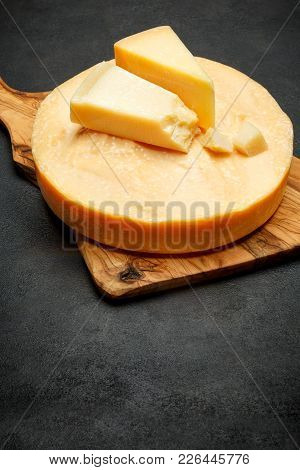 Whole Round Head Of Parmesan Or Parmigiano Hard Cheese On Concrete Background Or Table