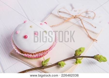 Easter Holiday Composition Of Decorated Cupcake, Branch With Young Shoots Of Greenery And Handcraft 