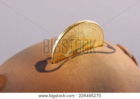 Close Up Of Bitcoin Symbolic Coin Inserted In The Piggy Bank