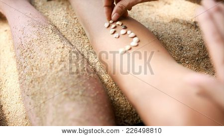 Female Hands Collect Pattern Of Shells And Sand, Close Up. Video. Girl Plays With Shells And Sand Si
