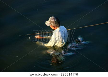 Amarapura, Myanmar - December 31: An Unidentified Man Fishes With A Spear In A Lake On December 31, 