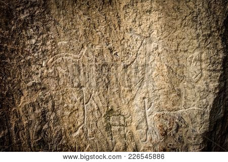 Ancient rock carvings petroglyphs of people with boat in Gobustan National park. Exposition of Petroglyphs in Gobustan near Baku, Azerbaijan.